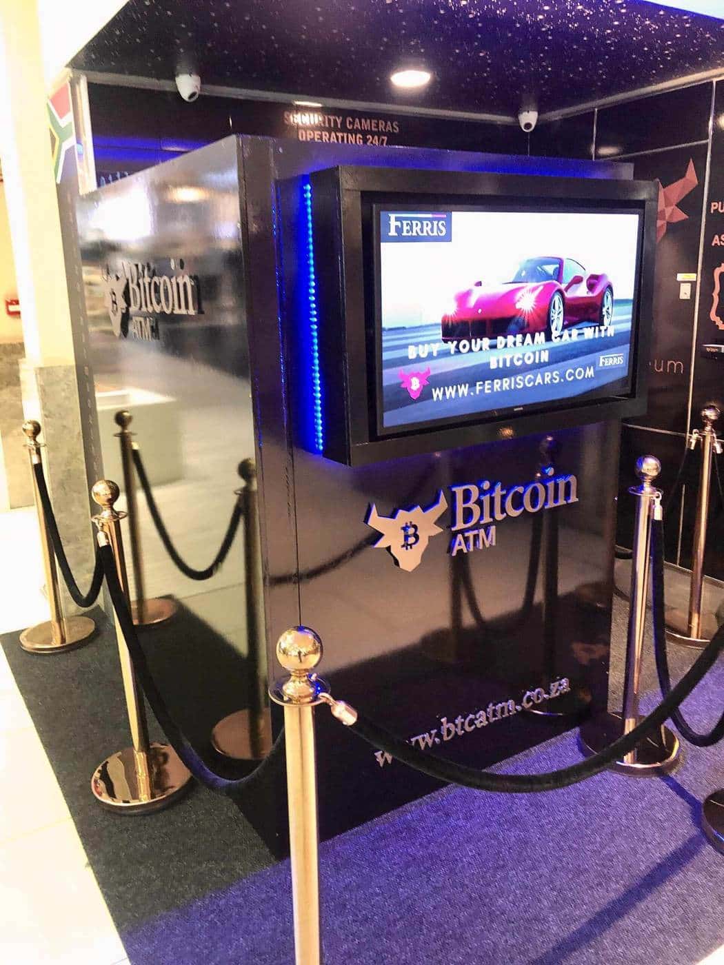 A bitcoin ATM kiosk with a screen inside a shopping centre display