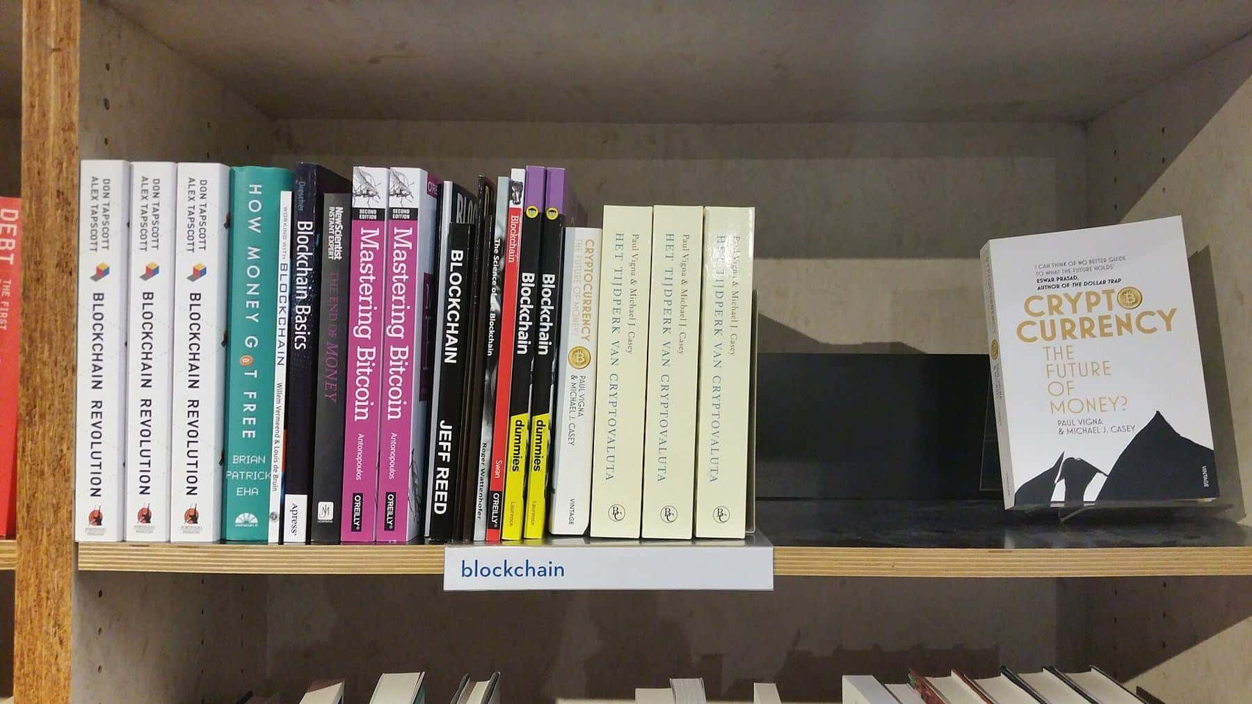 A library shelf of books about blockchain and cryptocurrency
